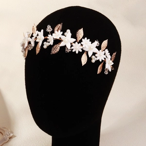 Detailed view of handmade bridal headband with gold leaves, white flowers and pearls