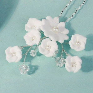 Detail of handmade clay flowers with white pearls and crystals on a silver U-shaped hair pin