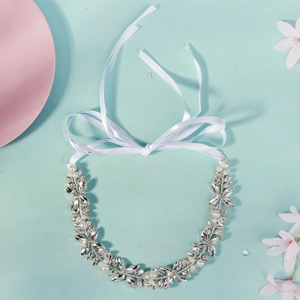 Détail d'un bandeau de mariée avec strass, perles et tissage de fils d'argent avec rubans
