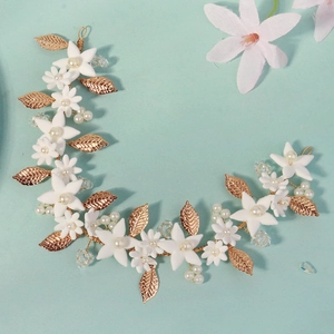 Detail of handmade gold leaf headband with white flowers and pearls for bridal hair