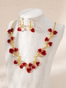 Detail von Brautschmuckset mit roten Rosen, Straßsteinen und Perlen auf Display