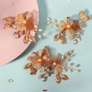 Détail de trois épingles à cheveux faites main en fil d'or avec perles et strass brillants