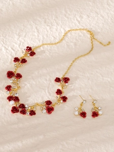 Details des Brautschmuck-Sets mit roten Rosen, goldenen Blättern und Perlen