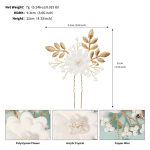 Macro view of gold leaf bridal hair pin with white flowers and acrylic crystals