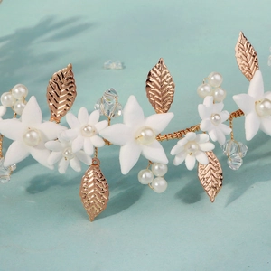 Detail of handmade gold leaf headband with white resin flowers and pearl accents