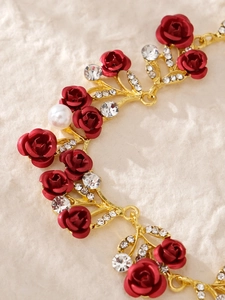 Details von goldenem Haarschmuck mit roten matten Rosen und Kristallakzenten