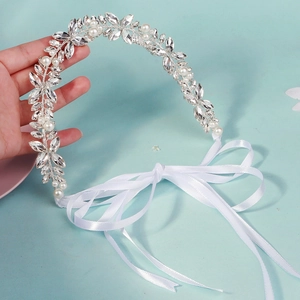 Détail d'un bandeau de mariée fait main avec strass, perles et ruban de satin blanc