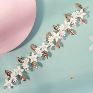 Detail of leaf headpiece with white flowers, gold metal leaves, pearls and crystals