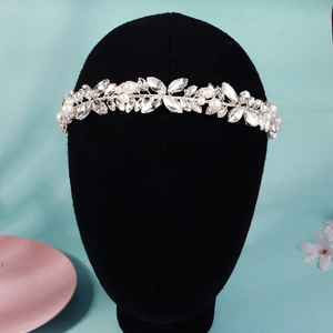 Détail d'un serre-tête de mariée fait main avec strass et perles sur un présentoir