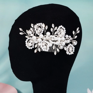 Close-up of bridal hair comb with pearls and marquise rhinestones on vine frame