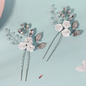 Detail of handmade ceramic flower hair pin with sparkling crystals and silver vines