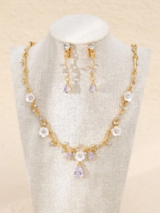 Details zum Brautschmuck-Set mit Blumen, Perlen und lila Kristallanhängern auf Weiß
