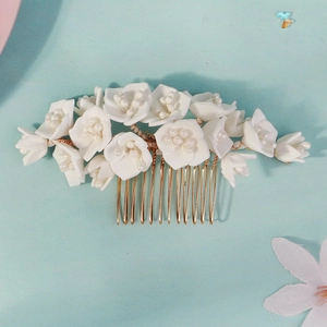 Peigne à cheveux élégant pour mariée avec pétales blancs et perles sur monture dorée