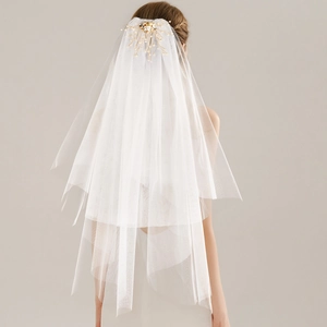 Détail du voile de mariée avec peigne à perles dorées et tulle blanc multicouche