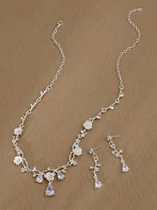 Makroaufnahme von Brautschmuck-Set aus Halskette und Ohrringen mit lila Strasssteinen