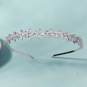 Close-up of elegant floral crystal headband with marquise stones on blue background