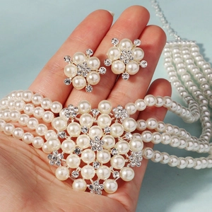 Macro shot of multi-layer pearl necklace and floral earrings with shimmering rhinestones