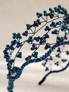 Detailed macro view of handmade blue crystal beads on baroque style woven headband
