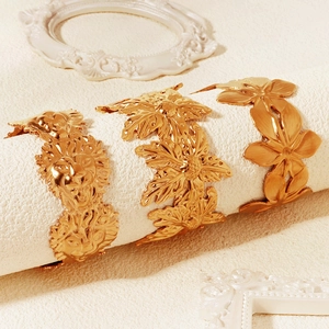 Detailaufnahme von drei vergoldeten Armreifen mit Löwen- und Blumenmotiven im Vintage-Stil