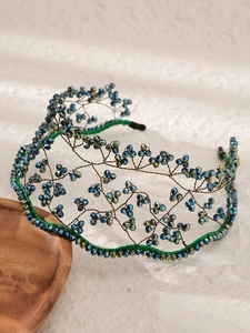 Macro detail of handmade baroque headband featuring blue and green faceted bead weaving