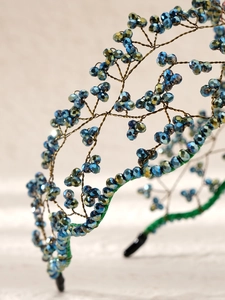 Detailed close-up of handmade bronze wire headband with blue crystal beads