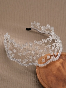 Macro detail of handmade beaded bridal headband with transparent crystals on leather background