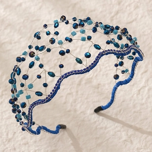 Détail d'un bandeau de mariée fait main avec des cristaux bleus et un tissage de fils d'argent
