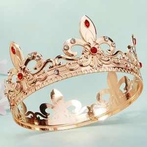 Close-up of golden Baroque crown featuring red rhinestones and ornate cutout patterns
