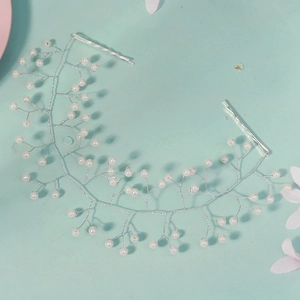 Detail of bridal hair vine with white pearls and silver wire on mint background