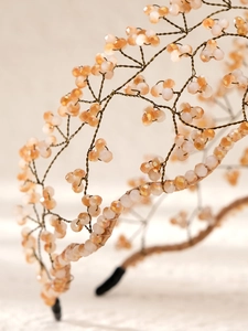Detailed view of handmade baroque headband with orange and cream crystal bead weaving