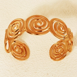 Detailansicht der goldenen Spiraltextur auf dem offenen Armreif im Meeresstil