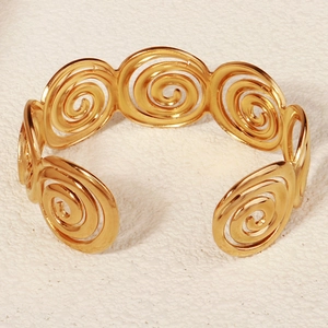 Detailansicht eines goldenen Manschettenarmbands im Meeresstil mit spiralförmiger Struktur