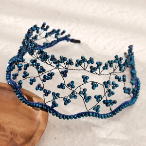 Handmade beaded headband featuring deep blue crystal branches on a textured background