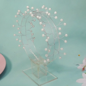 Handmade bridal pearl headband with silver copper wire branches on a green background