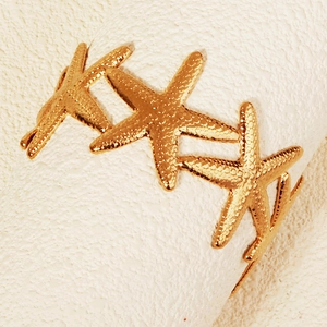 Makroaufnahme des goldenen Seestern-Armreifs mit realistisch geprägten Texturdetails
