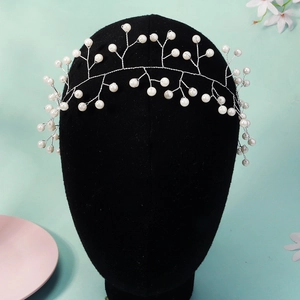 Detailed macro view of handmade pearl hairpiece with silver wire and white pearls