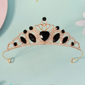 Detailed close-up of golden crown with black heart crystal and sparkly rhinestones