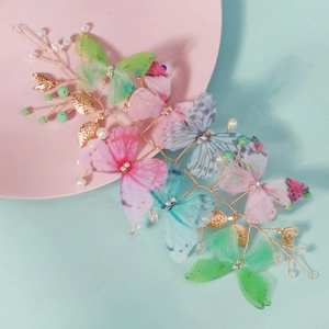 Détail de la pince à cheveux papillon faite main avec des ailes en maille et des perles