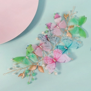 Détail de papillons en maille colorée avec perles et cristaux sur pince à cheveux dorée