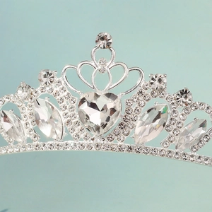 Detailed close-up of a silver crown featuring heart-shaped crystals and sparkling rhinestones