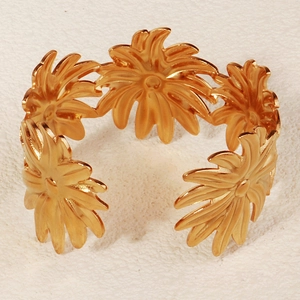 Details eines mattgoldenen Manschettenarmbands im Meeresstil mit Blütenblatt-Elementen