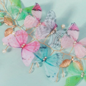 Détail d'une barrette papillon en tulle faite main avec des perles et des cristaux