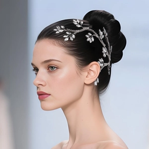 Detailed view of silver bridal hairpiece with crystal leaves styled on elegant bun hairstyle