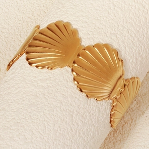 Detailansicht eines goldenen Armbands im Muschel-Design mit texturierter Optik