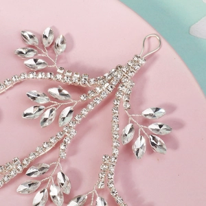 Close-up of silver bridal headpiece featuring intricate leaf vine with crystals and rhinestones