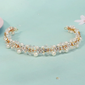 Detail von Braut-Stirnband mit weißen Perlen und funkelnden Kristallblumen auf Golddraht