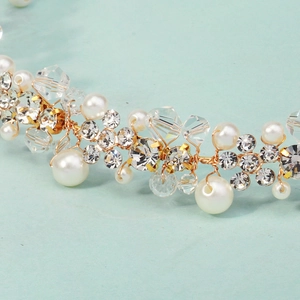 Nahaufnahme von handgefertigtem Brautschmuck mit weißen Perlen und goldener Blumendrahtarbeit