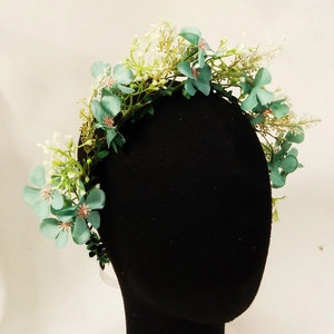 Close-up of mint green and white floral headband with realistic leaf details