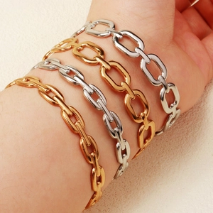 Dettaglio di bracciali a catena in acciaio inossidabile oro e argento al polso