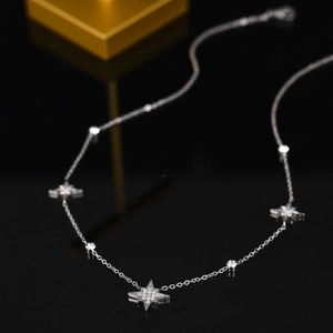 Elegante silberne Sternenhalskette mit Zirkonia-Anhängern auf edlem schwarzem Hintergrund